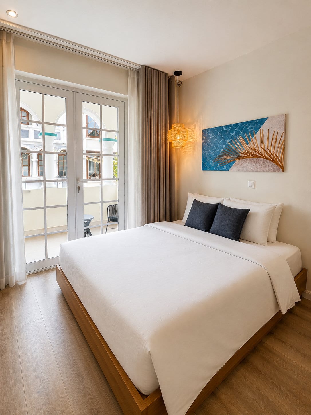A Signature King Room with Balcony at Majestic City Palace, a king bed in white linen beside tall French doors opening onto the private loggia over Breedestraat