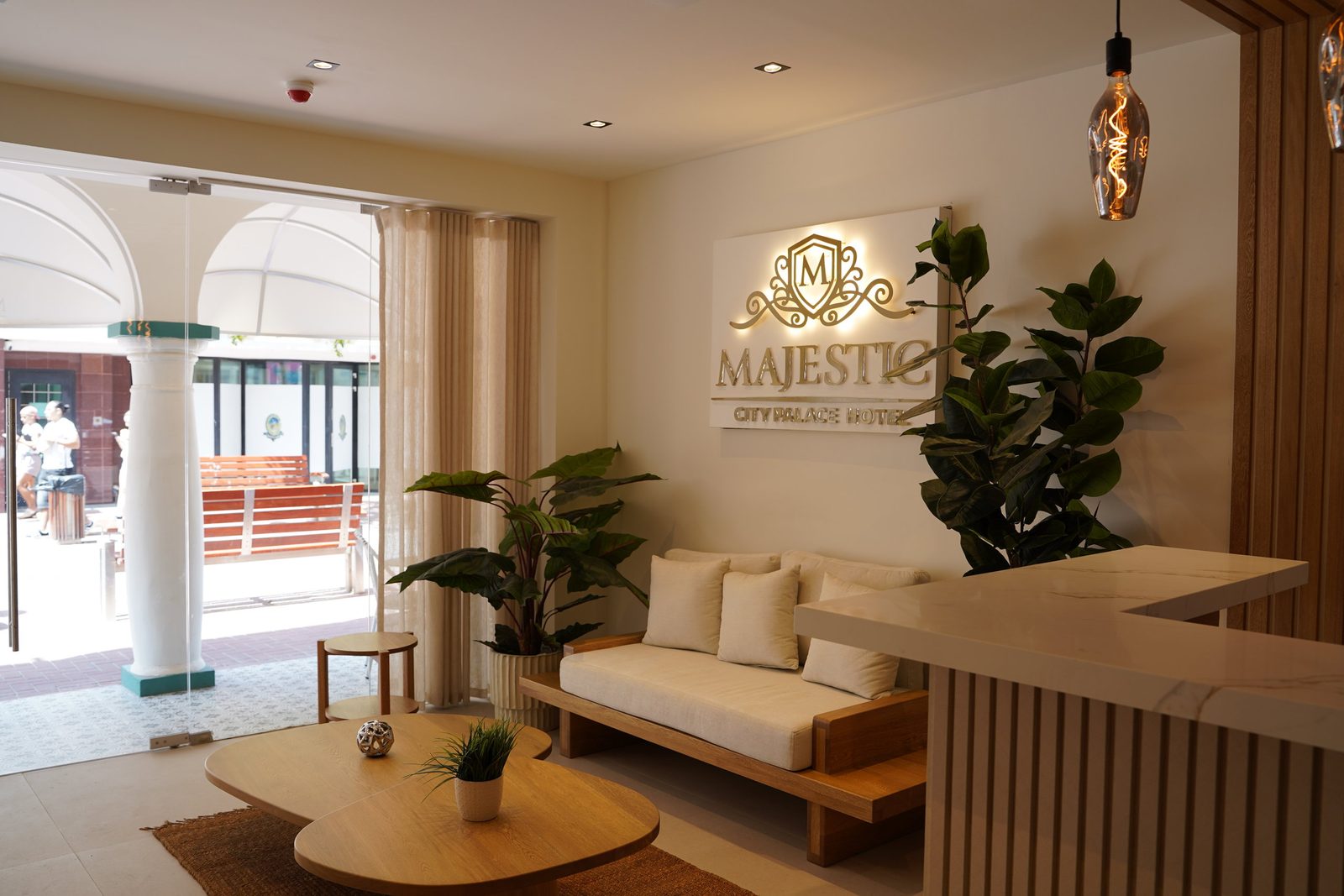 The guest lounge at Majestic City Palace with cream sofas, oak tables and white arches