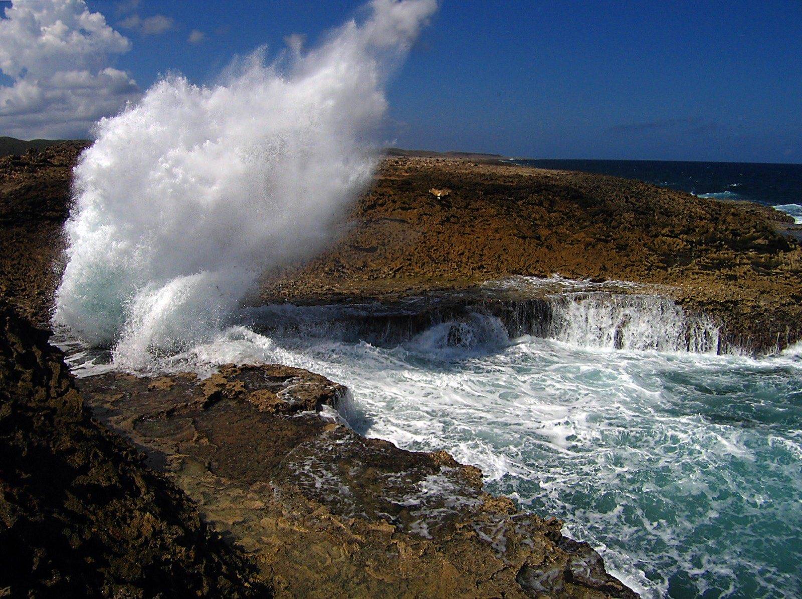 A wave exploding upward through the Boka Pistol blowhole on the north coast of Curaçao
