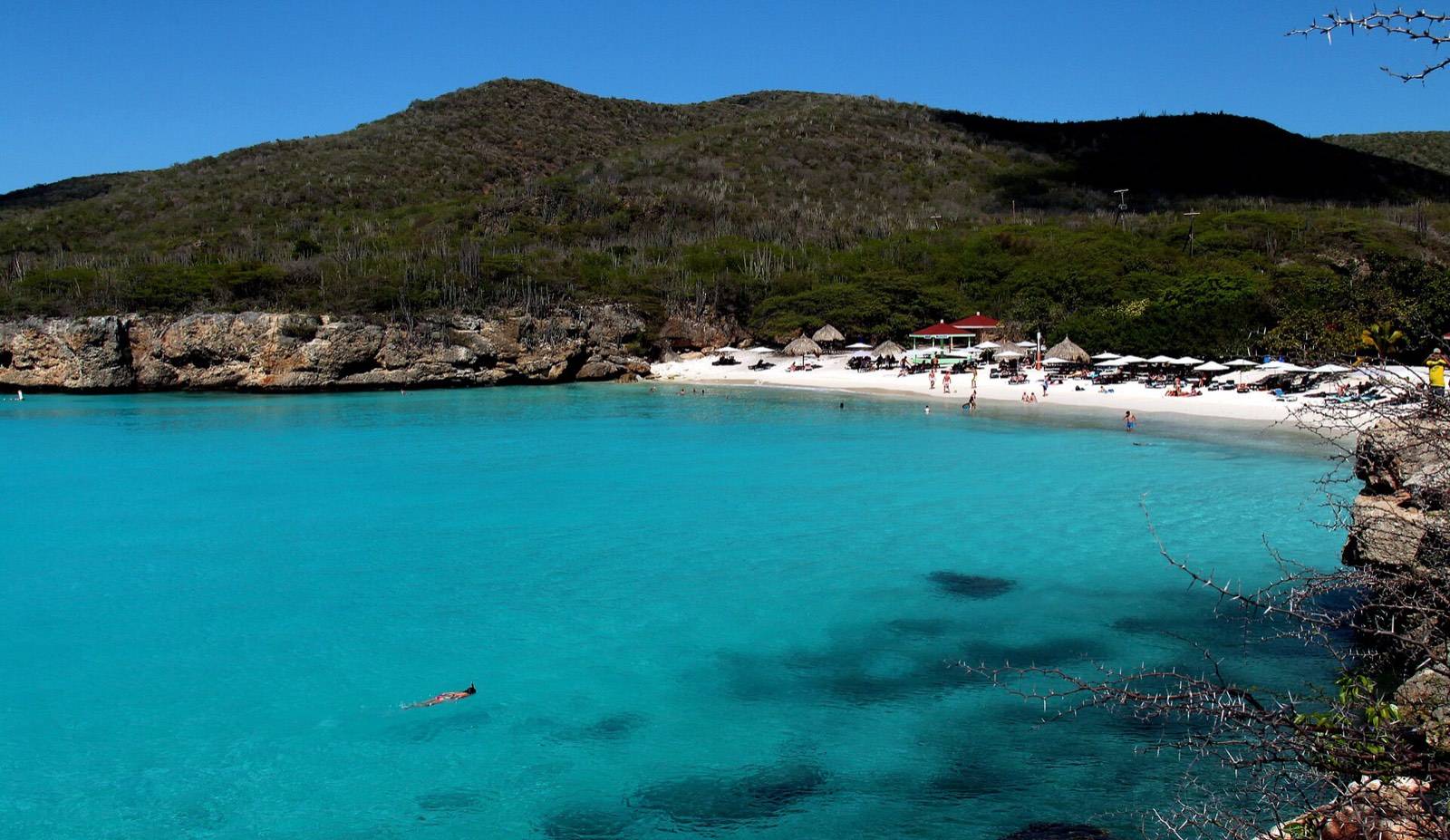 The turquoise cove of Kenepa Grandi framed by green cliffs on the west end of Curaçao