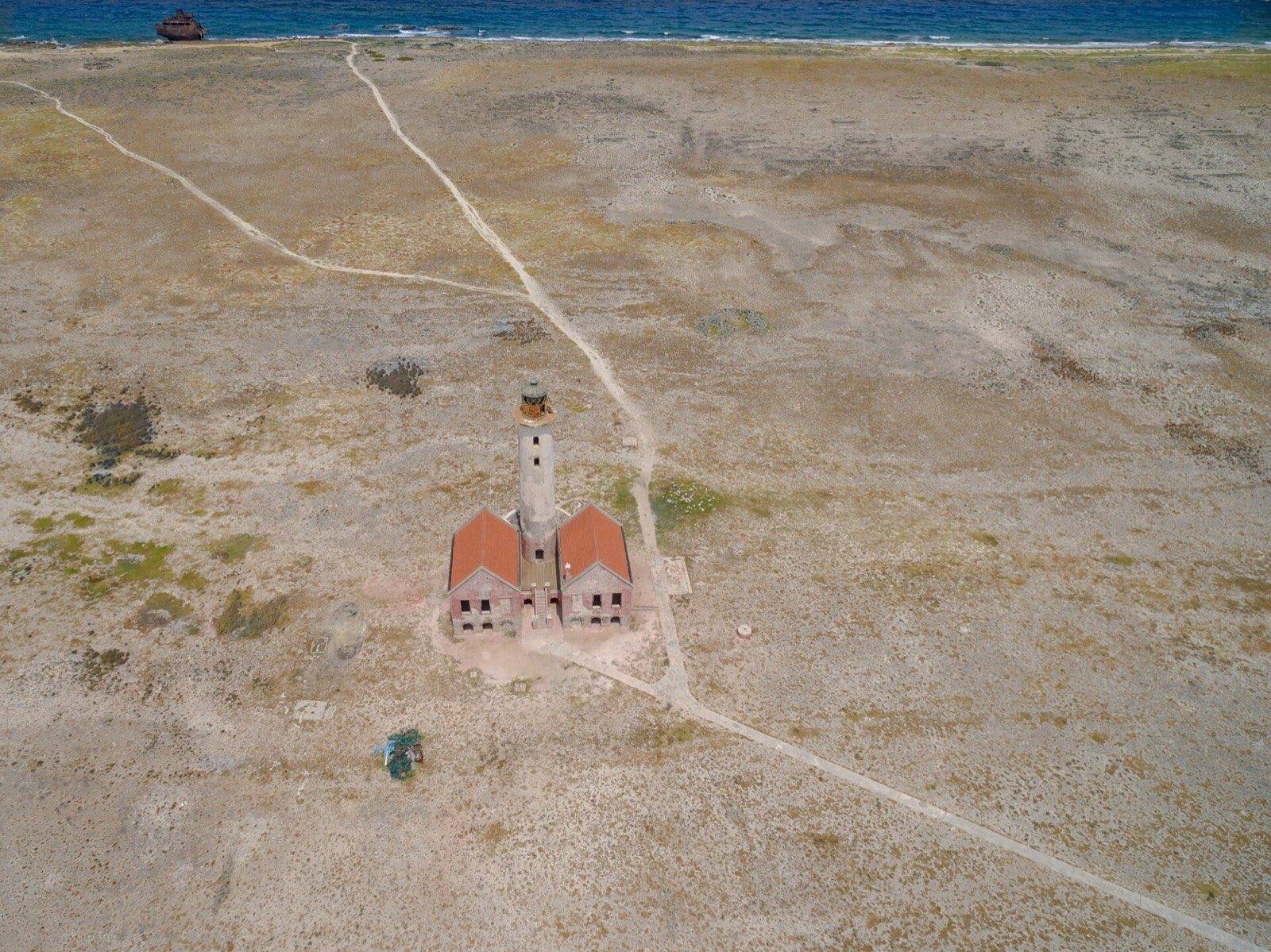 The rust-colored lighthouse standing over the bare white sand of Klein Curaçao