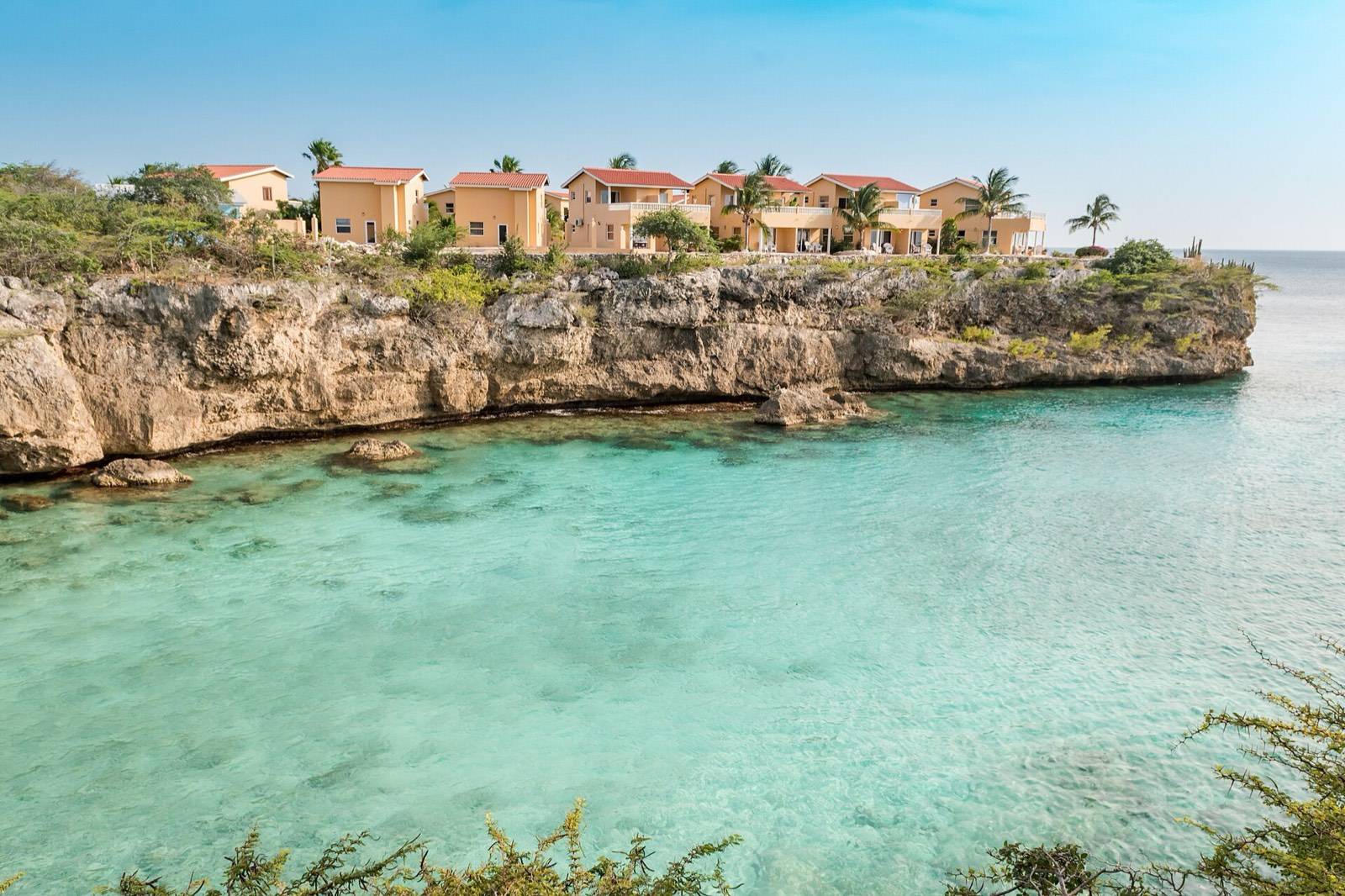 Fishing boats and calm water between the cliffs of Playa Lagun, a popular shore-dive entry