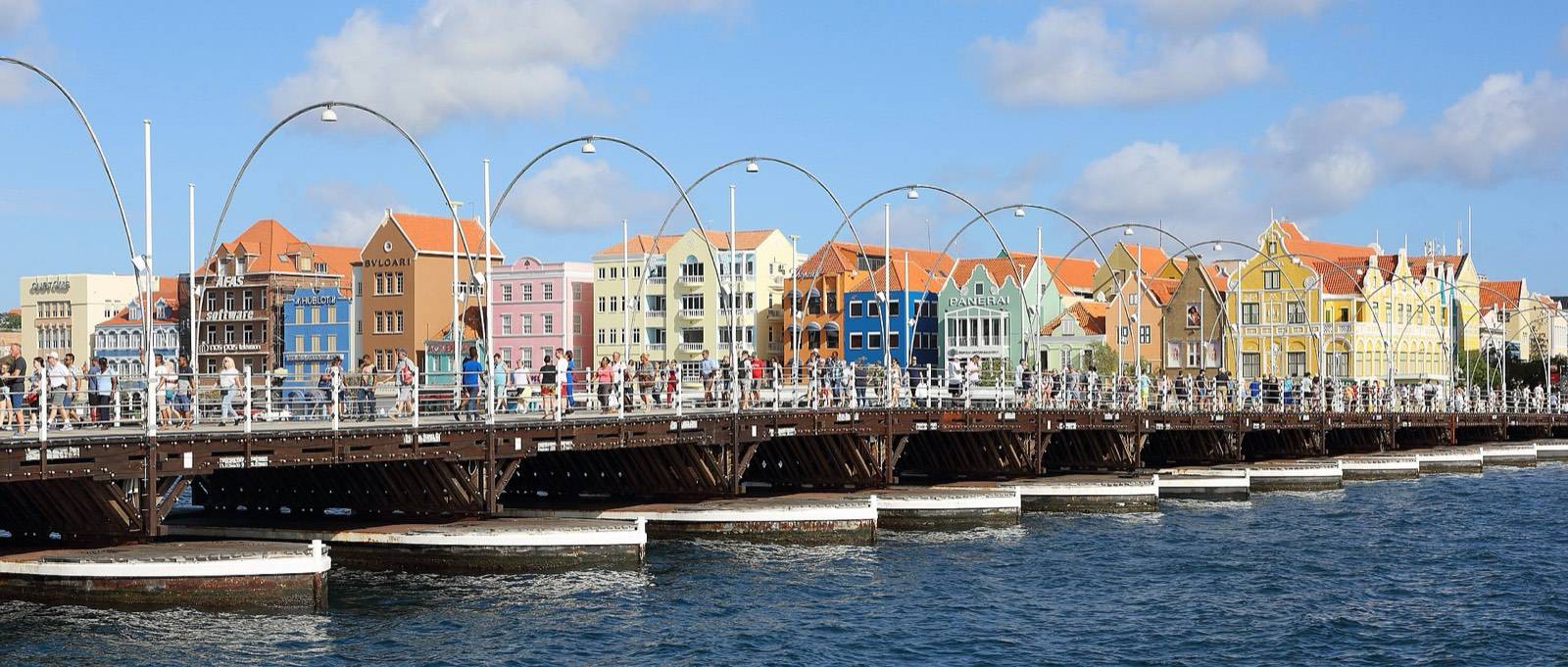 The Queen Emma pontoon bridge stretching toward the colorful Handelskade waterfront in Punda