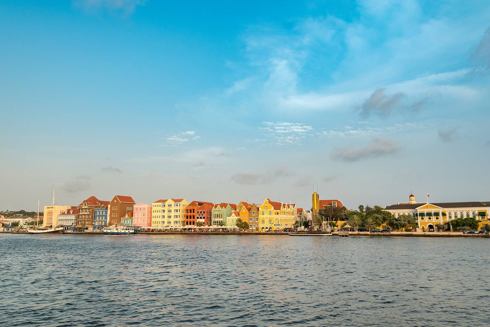 The pastel skyline of Willemstad, Curaçao, seen across the water on a bright day
